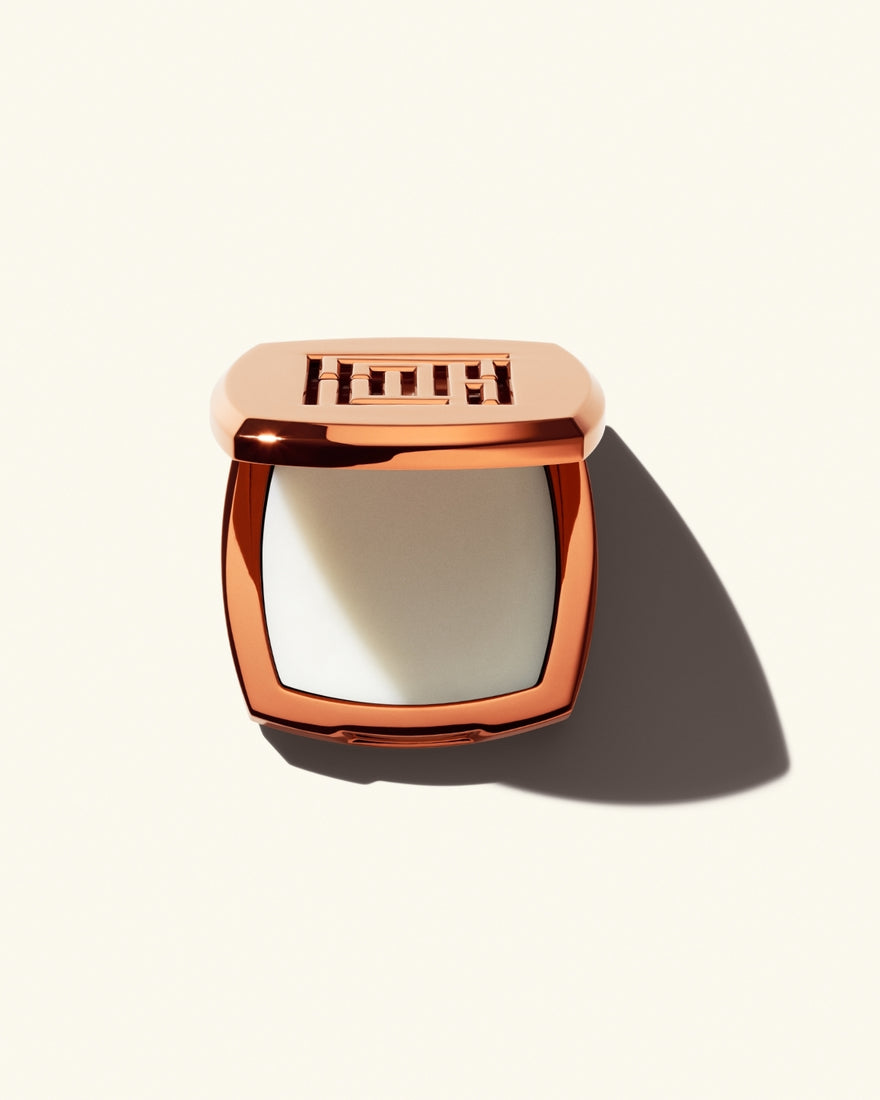 Open shot of Fenty Fragrance Solid Parfum on a cream background
